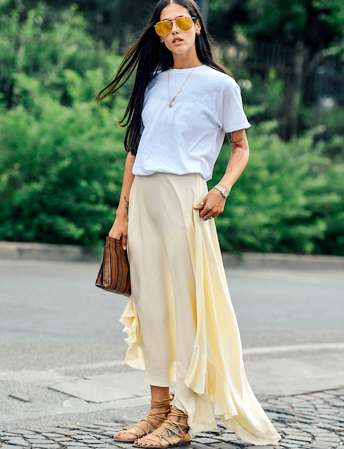 Femme portant un tee-shirt blanc avec une longue jupe fluide couleur crème